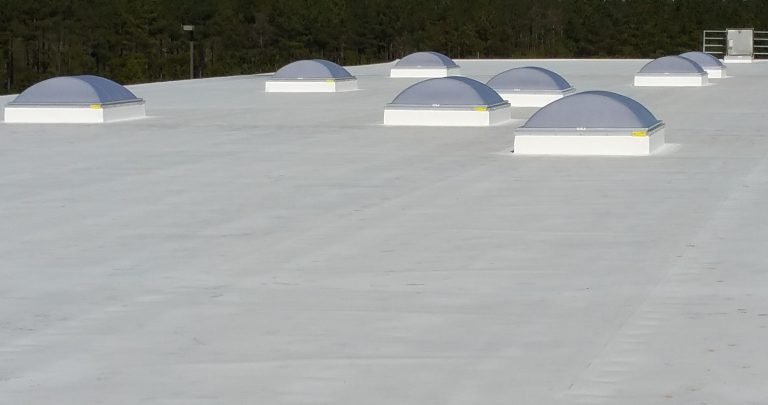 Commercial flat roof with multiple skylights, showcasing a durable roofing system designed for energy efficiency and natural lighting.
